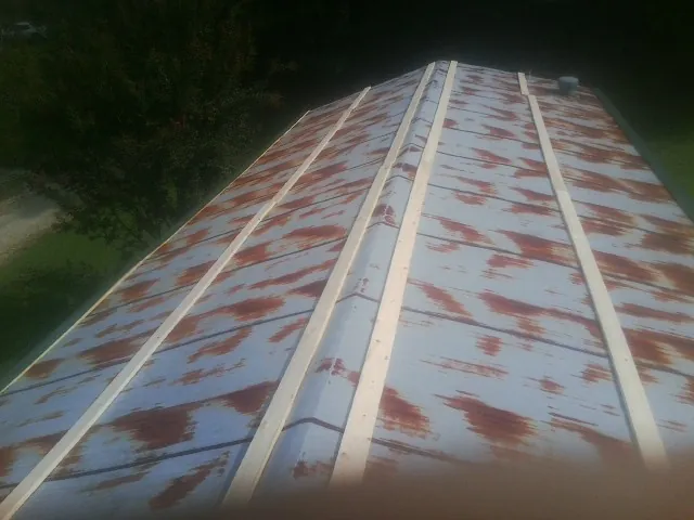 Rusted metal roof panels with new wood purlins before replacement — Storm Damage Roof Repair in Unionville by Roofing Brothers